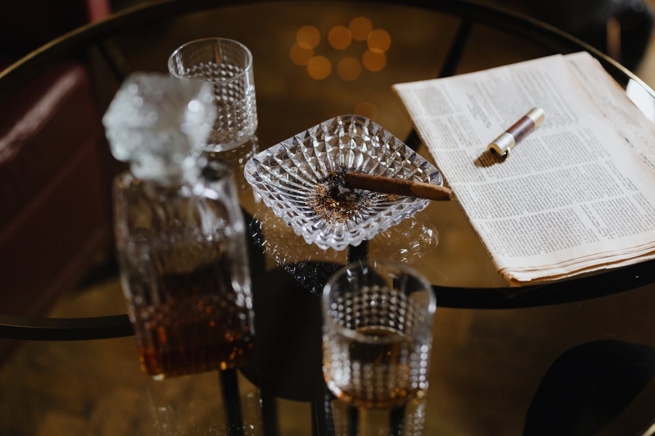 About Elegant composition featuring a cigar and whiskey on a glass table, exuding luxury and sophistication.